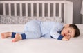 ÃÂ¡ute little baby boy in light blue pajamas sleeping peacefully on bed at home.